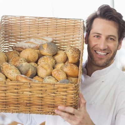 image of a man holding a plate of bread within the food industry